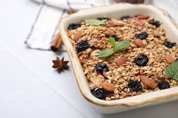 Tasty baked oatmeal with berries and almonds on white table, closeup. Space for text