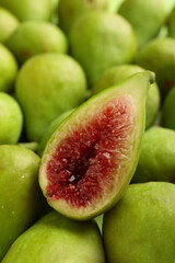 Half of green fig on fresh fruits, closeup