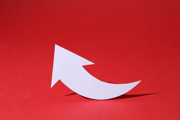 White curved paper arrow on red background