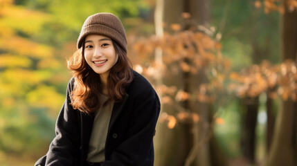 秋の公園で丸太に腰掛け一休みする日本人女性のポートレート