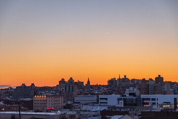 Sunrise over the skyline of Red hook New York as seen from a subway platform in Gowanus at golden hour.  - obrazy, fototapety, plakaty
