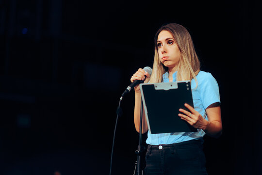 Stressed Speaker Holding a Clipboard Taking on a Microphone ion a Stage. Anxious shy person suffering from stage fright afraid to perform in publi
