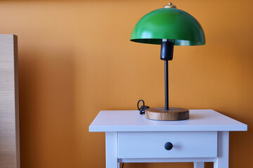 table lamp against orange color wall in bed room 