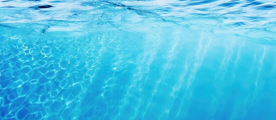 Summer background featuring the textured surface of a blue swimming pool