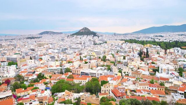 Athens Greece street cityscape high angle aerial Acropolis view on roof rooftop buildings, mount Lycabettus hill, temple of Olympian Zeus panning shot