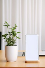 Mockup smartphone with blank screen on table with green plant