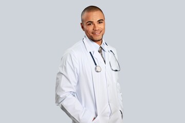 Fototapeta premium Professional doctor in medical coat over light wall background