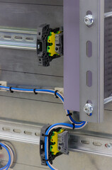 A metal chassis with din rails mounted on it on which modules are installed in an electrical switchboard.