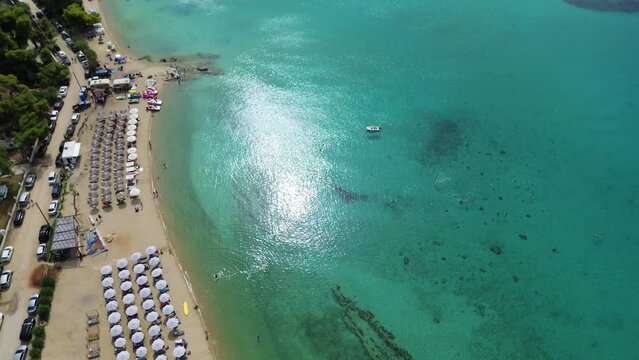 Kalogria Beach Aerial View of sandy paralia Kalogria close to Nikiti and Elia Nikitis in Halkidiki, Greece. Turquoise clear blue water from above with water reflexion and people on the beach