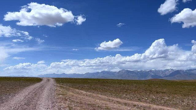 The Alai Valley is drowned in clouds, and the road leads to the base camps of Lenin Peak. An inter-mountain depression in the Pamir-Alay mountain system in the Osh region of Kyrgyzstan. 4К