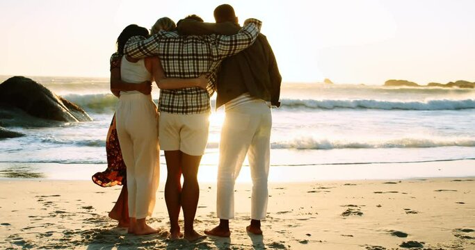 Four Friends on the Beach Standing and Watching the Sunset 