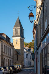 Vue du centre de Viroflay, France, avec la rue Jean-Rey et le clocher de l'église catholique Saint-Eustache, construite au 16ème siècle - obrazy, fototapety, plakaty