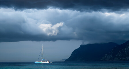 Tranquil Anchorage: Catamaran Amidst Mallorca's Cloudy Coast