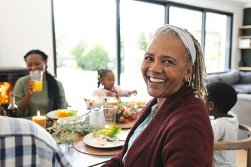Portrait of african american grandmother with family at thanksgiving dinner table