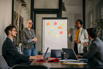 A diverse team of professionals representing various ethnicities and genders participating in a lively office meeting, showcasing teamwork and diversity