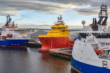 Offshore platform supply vessels in port moored closely together. - obrazy, fototapety, plakaty