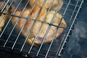 Chicken meat grilling on the brazier. Selective focus.