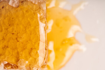 Fresh honeycomb with liquid honey on the white plate. Selective focus.