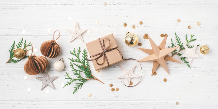 Festive Christmas Background With Gift Box And Christmas Decorations On White Wooden Table. Top View.