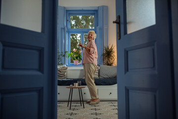 Elderly woman dancing in her apartment - 656900549