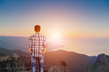 Fototapeta premium Person stands on a mountain peak looking in beautiful view