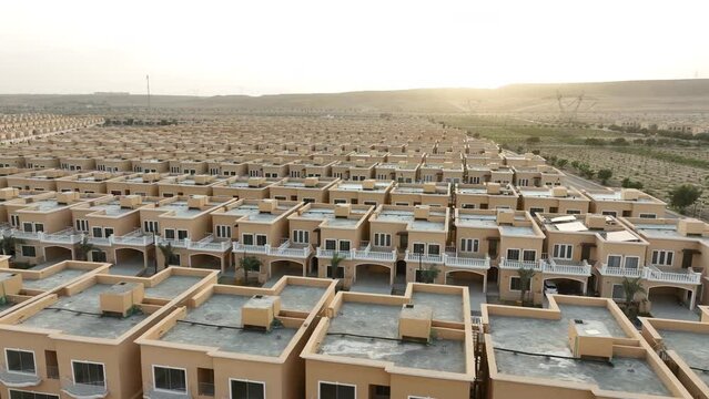 Low-angle drone shot of a newly constructed housing society over a large land in Pakistan. Housing society idea