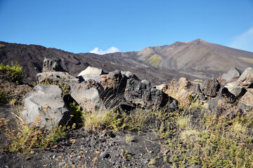 Mount Etna, Sicily, Italy. Slopes of volcano are covered with volcanic ash and frozen lava. Summer mountain landscape on sunny day