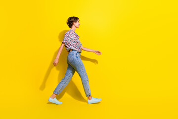 Full body profile portrait of stunning satisfied lady look walk empty space ad isolated on yellow color background