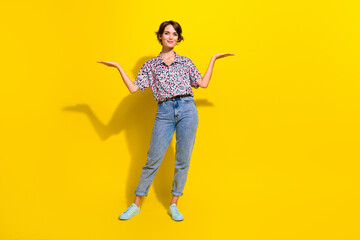 Full size portrait of pretty positive girl arms hold demonstrate empty space proposition isolated on yellow color background