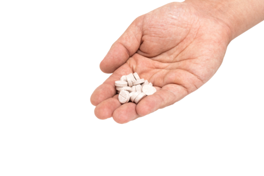 Round therapeutic pills or drugs for treatment in male hand palm isolated on transparent background, medicine and healthcare concept, close-up view

