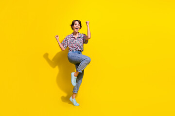 Fototapeta na wymiar Full size portrait of overjoyed cheerful girl raise fists shout yes hooray empty space isolated on yellow color background
