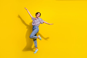 Fototapeta na wymiar Full body portrait of lovely overjoyed lady raise arms have good mood dancing partying empty space isolated on yellow color background