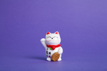 a trendy Maneki-neko plastic cat on violet background