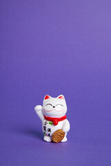 a trendy Maneki-neko plastic cat on violet background