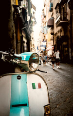 Old scooter in a downtown street of Naples with an italian flag on it - 656915365