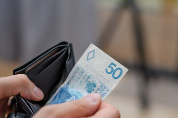 Banknot 50 złotych polskich pln wyciągany z portfela, płacić za zakupy - obrazy, fototapety, plakaty