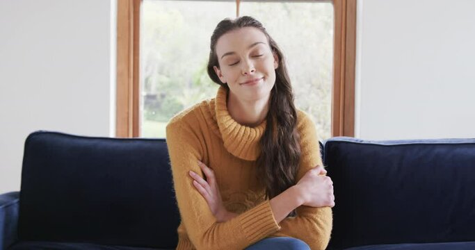 Happy caucasian woman sitting on sofa and having video call in sunny living room,copy space