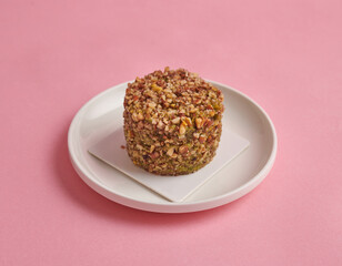 cake with caramelized nuts on pink background