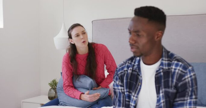 Angry diverse couple arguing and shouting in bedroom at home,slow motion