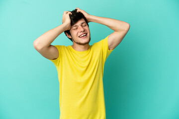 Young Russian man isolated on blue background laughing