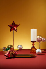 Golden tray displayed with a pair of bell, scented candle and some beautiful bauble. It is also...