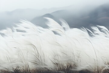 Obraz premium A background image showcasing windswept reeds with majestic mountains in the distance, creating a picturesque setting for a variety of creative projects. Photorealistic illustration