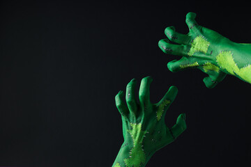 Green female hands on black background, space for text