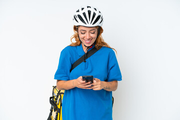 Young caucasian woman with thermal backpack isolated on white background sending a message with the mobile