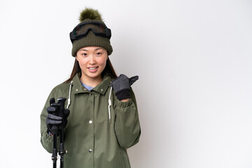 Young Chinese woman wearing winter jacket isolated on white background pointing to the side to present a product