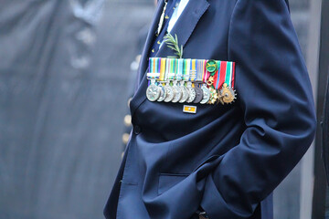 Sydney, NSW Australia - April 25 2021: Anzac Day March. A man in a blue suit wearing medals and rosemary