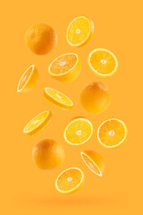 Juicy oranges as flow fly or fall as art composition. Whole, half, round slices fruits on pastel...