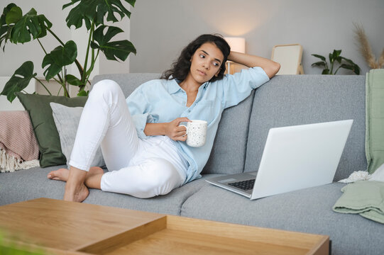 Young woman relaxing and watching movie on laptop at home