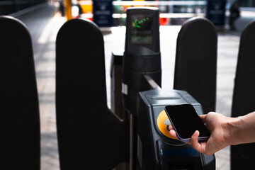 Businesswoman scanning turnstile with smart phone at railroad station