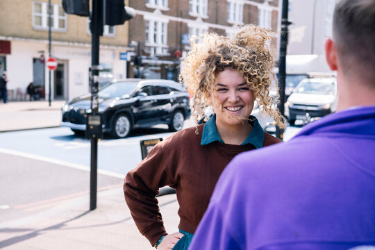 Smiling businesswoman discussing with colleague at street